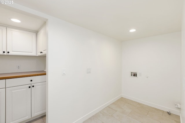 clothes washing area with washer hookup and cabinets