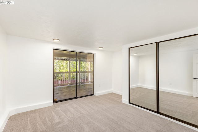 unfurnished bedroom featuring a closet, light carpet, and access to outside