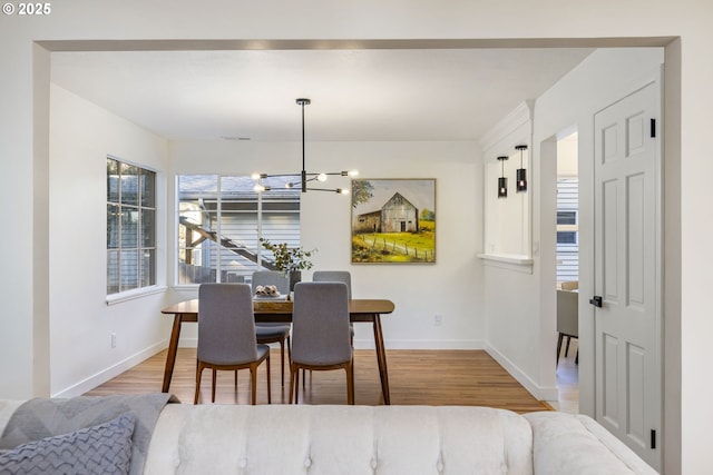 dining space with hardwood / wood-style flooring and a chandelier