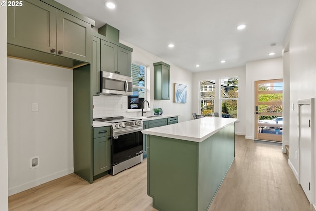 kitchen with stainless steel appliances, a center island, and green cabinets