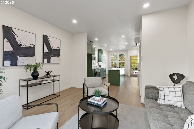 living room featuring sink and light hardwood / wood-style floors