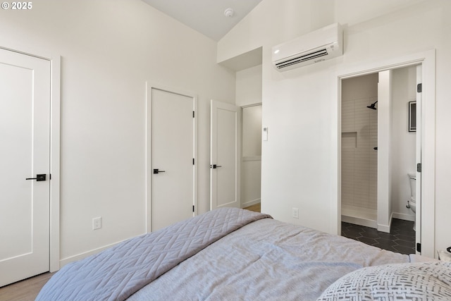 bedroom featuring vaulted ceiling, a wall unit AC, and dark tile patterned floors