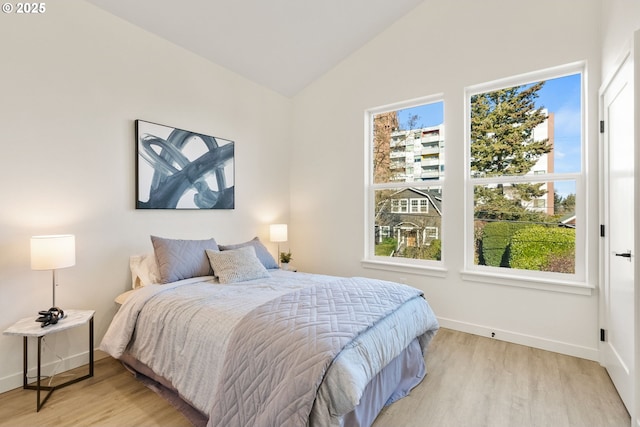 bedroom featuring lofted ceiling and light wood-type flooring