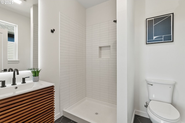 bathroom with tile patterned flooring, a tile shower, and toilet