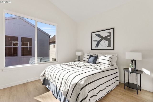 bedroom with lofted ceiling and light wood-type flooring