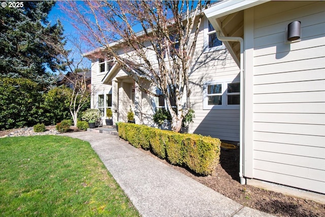 view of exterior entry with a lawn