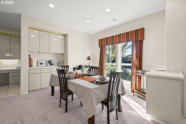 dining space with recessed lighting and light colored carpet