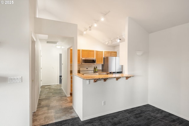 kitchen with visible vents, light stone counters, a kitchen breakfast bar, a peninsula, and stainless steel appliances