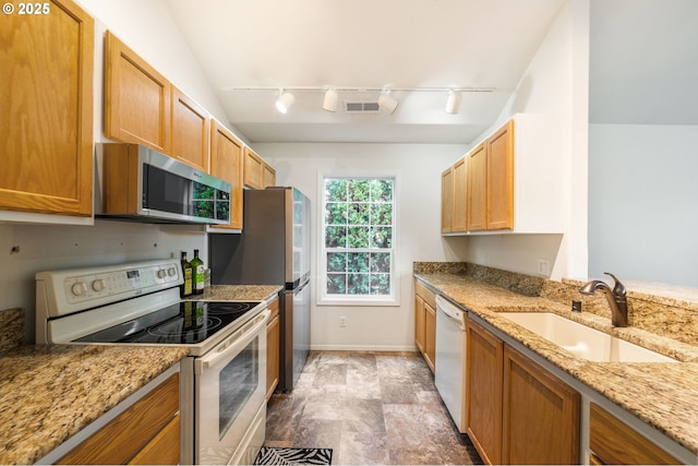 kitchen with stainless steel appliances, a sink, visible vents, and light stone countertops