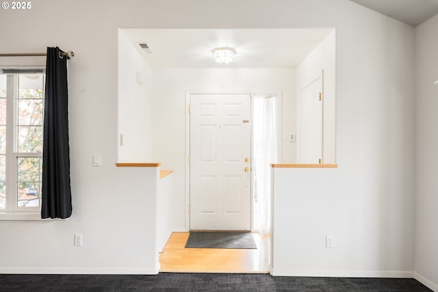 foyer featuring wood finished floors, visible vents, and baseboards