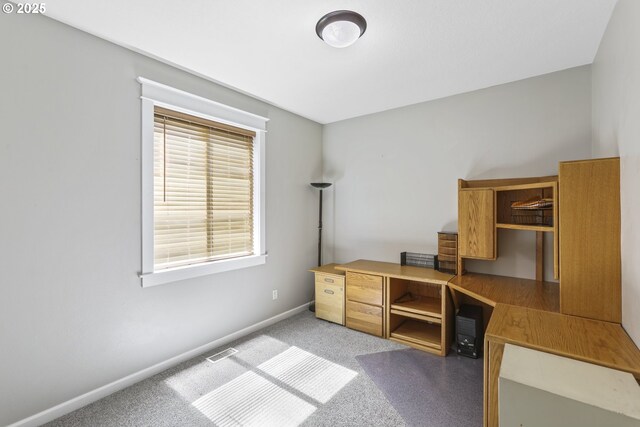 unfurnished office with visible vents, baseboards, and light carpet