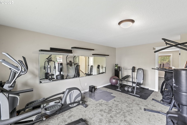 workout room featuring a textured ceiling, baseboards, and carpet