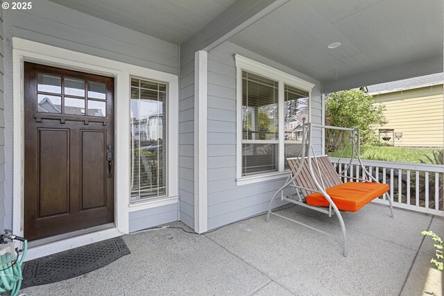 view of exterior entry featuring covered porch