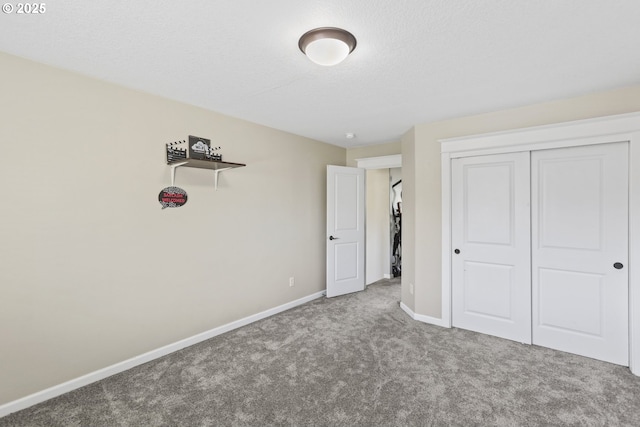 unfurnished bedroom featuring a closet, baseboards, carpet flooring, and a textured ceiling
