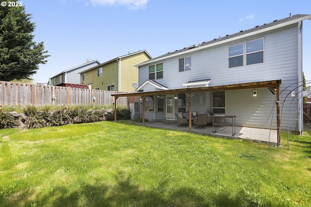 rear view of property featuring a fenced backyard, a patio, and a lawn