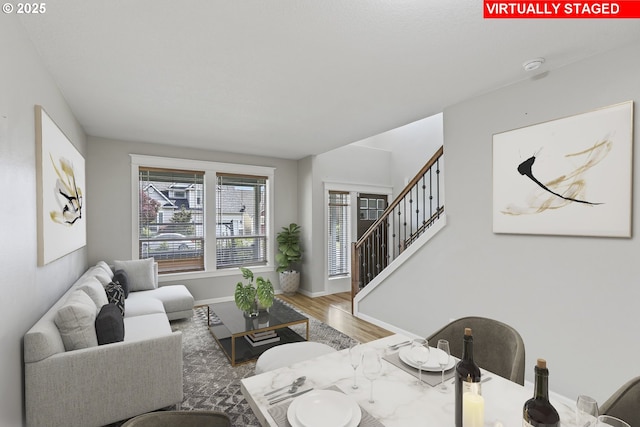 living room with baseboards, stairs, and wood finished floors