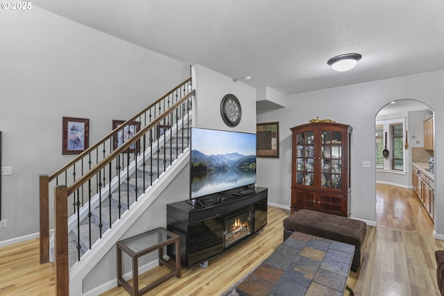 living room featuring light hardwood / wood-style floors and a textured ceiling