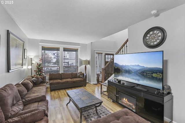 living room with plenty of natural light, light hardwood / wood-style floors, and a textured ceiling