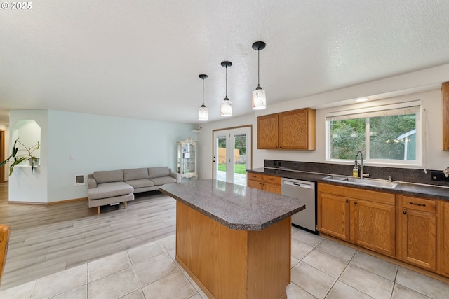 35363 Bayside Gardens Rd, Nehalem, OR 97131 - kitchen with a sink, stainless steel dishwasher, a center island, dark countertops, and healthy amount of natural light