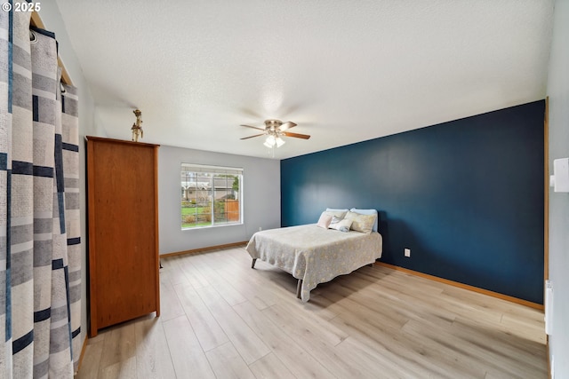 35363 Bayside Gardens Rd, Nehalem, OR 97131 - bedroom with light wood-style floors, baseboards, and ceiling fan