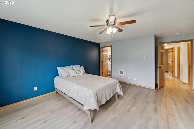 bedroom with a ceiling fan, baseboards, visible vents, and light wood-style floors
