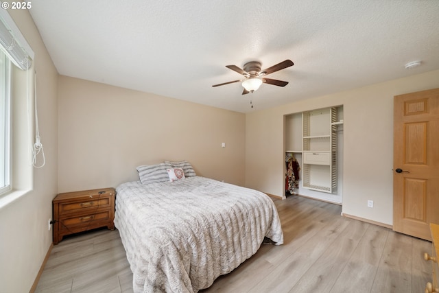 35363 Bayside Gardens Rd, Nehalem, OR 97131 - bedroom featuring light wood-style floors, a ceiling fan, baseboards, and a closet
