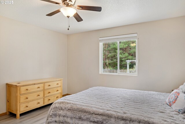 bedroom with a ceiling fan and light wood-style flooring
