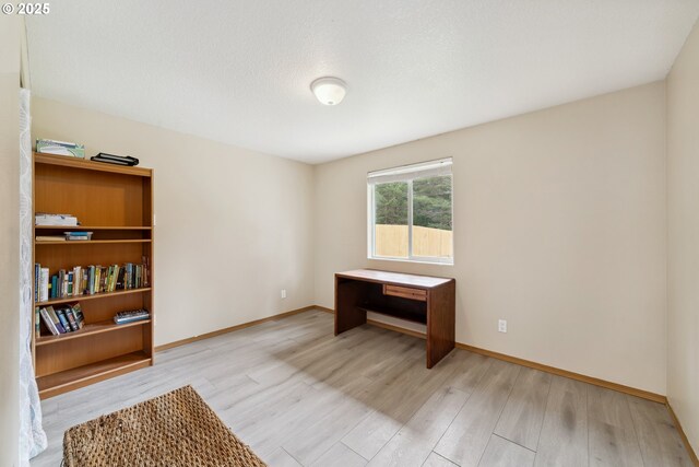 interior space with baseboards and light wood-style flooring