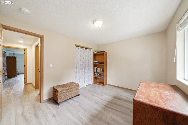 interior space featuring baseboards, a wealth of natural light, and light wood-style flooring