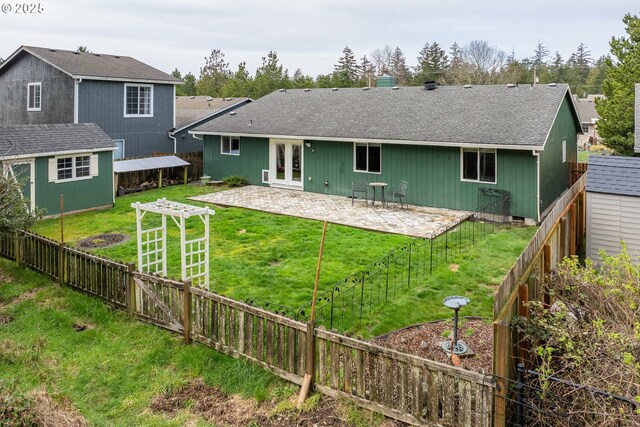 back of house featuring fence, a patio, a lawn, and roof with shingles