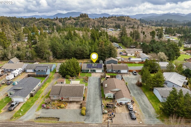 drone / aerial view with a residential view, a mountain view, and a forest view