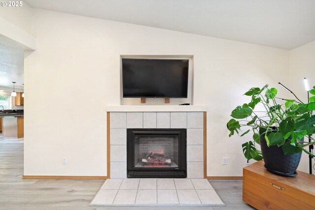 details with baseboards, wood finished floors, and a fireplace