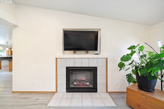 35363 Bayside Gardens Rd, Nehalem, OR 97131 - detailed view of wood finished floors, baseboards, and a tile fireplace