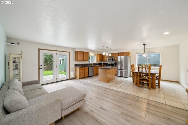 living area featuring light wood-style floors, baseboards, recessed lighting, and a textured ceiling