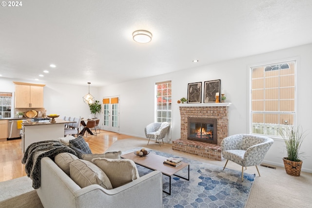 living area with light wood finished floors, visible vents, recessed lighting, and a fireplace