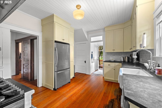 3113 SE Main St, Portland, OR 97214 - kitchen with freestanding refrigerator, dark countertops, a sink, backsplash, and light wood finished floors