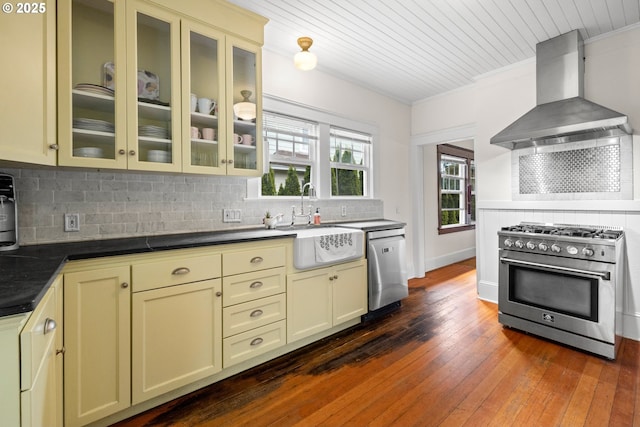 3113 SE Main St, Portland, OR 97214 - kitchen featuring stainless steel appliances, wall chimney range hood, a sink, dark wood-style flooring, and dark countertops