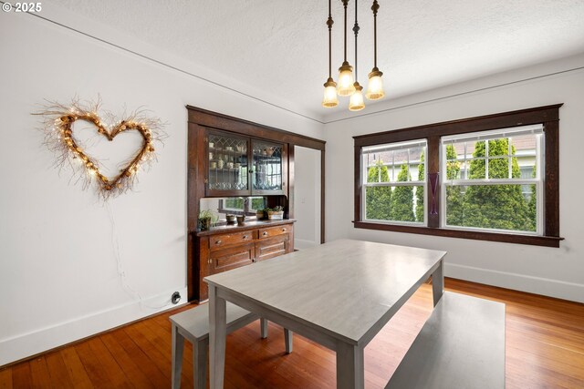 3113 SE Main St, Portland, OR 97214 - dining room featuring a chandelier, baseboards, wood finished floors, and a textured ceiling