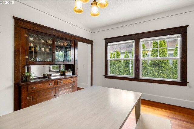 3113 SE Main St, Portland, OR 97214 - bedroom with a chandelier, wood finished floors, and baseboards