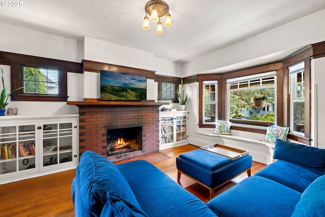 3113 SE Main St, Portland, OR 97214 - living area featuring a fireplace, wood finished floors, and a textured ceiling