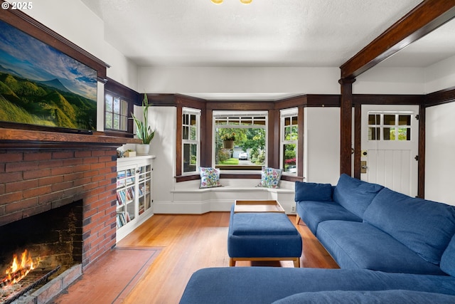 3113 SE Main St, Portland, OR 97214 - living room with wood finished floors, a fireplace, beamed ceiling, and baseboards