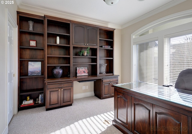 home office with light carpet, a wealth of natural light, ornamental molding, and built in desk