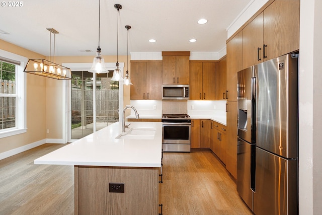 2220 NE Brendan Cir, Vancouver, WA 98663 - kitchen with stainless steel appliances, light wood finished floors, light countertops, recessed lighting, and decorative light fixtures