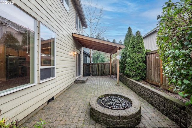 view of patio featuring an outdoor fire pit and a fenced backyard