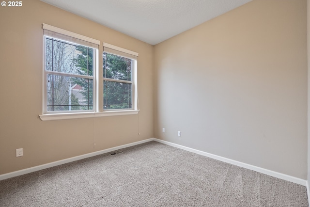 carpeted empty room featuring visible vents and baseboards