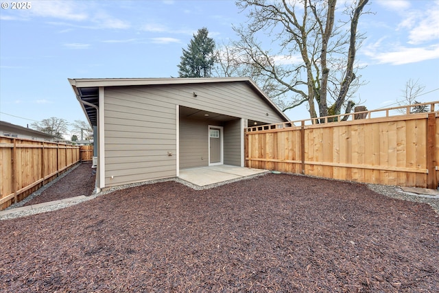 rear view of house featuring a patio and a fenced backyard