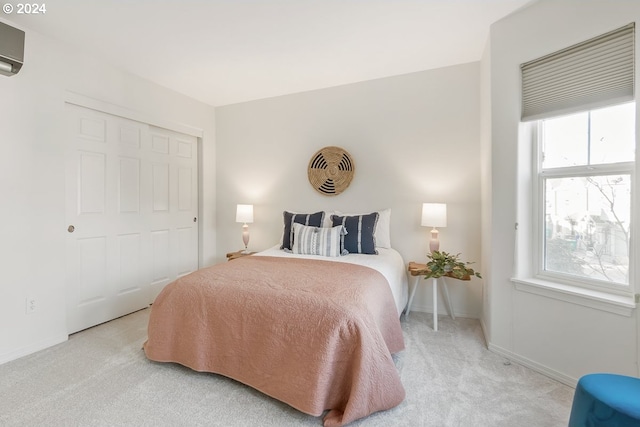 carpeted bedroom featuring a wall mounted AC and a closet