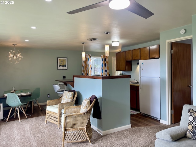 54825 Robinson Rd, Coquille, OR 97423 - kitchen featuring freestanding refrigerator, baseboards, a chandelier, decorative light fixtures, and carpet flooring
