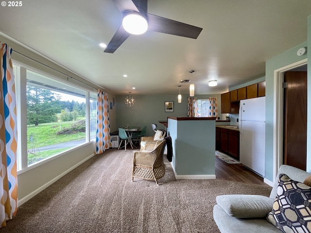 54825 Robinson Rd, Coquille, OR 97423 - living room with dark carpet, baseboards, ceiling fan, and a chandelier
