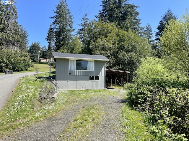 54825 Robinson Rd, Coquille, OR 97423 - view of front facade featuring dirt driveway, board and batten siding, and an outbuilding
